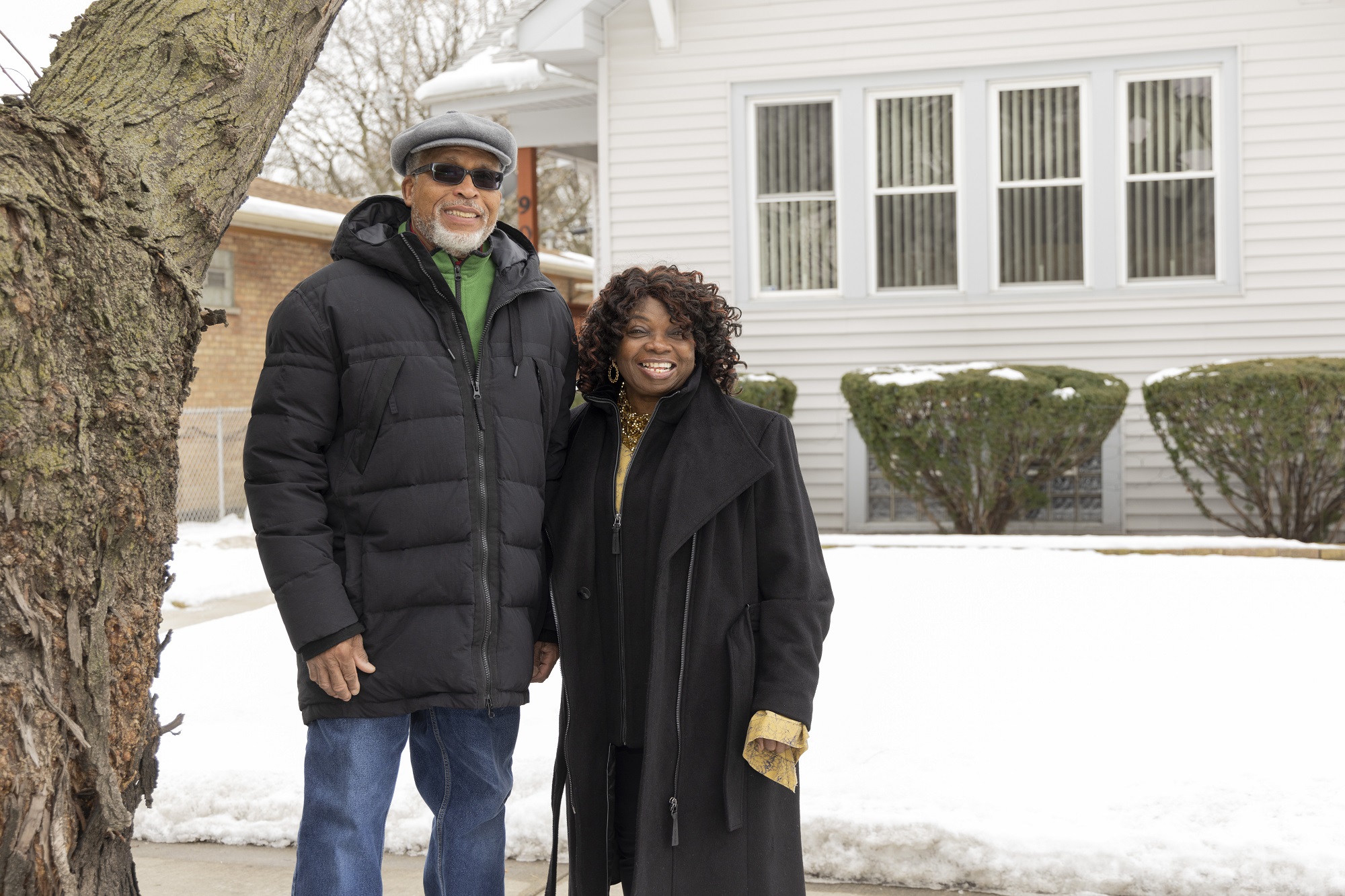 BlueHub SUN homeowners Jettie & Jacquelyn Cooper outside of their family home in the snow.